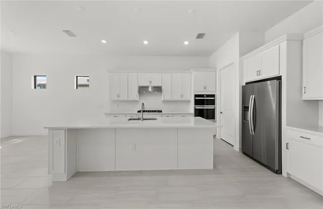 a kitchen with stainless steel appliances a refrigerator sink and cabinets