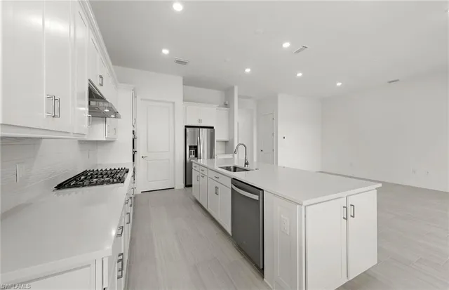a kitchen with white cabinets and stainless steel appliances