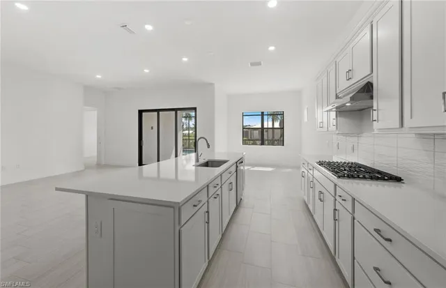 a kitchen with white cabinets sink and stove