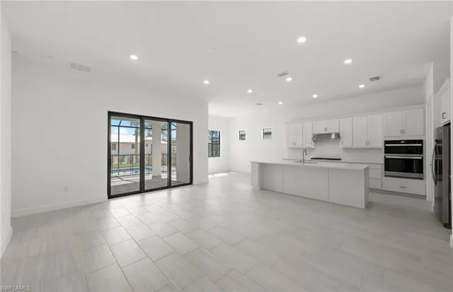 a living room with stainless steel appliances kitchen island furniture and a fireplace