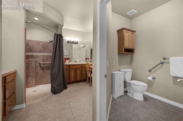 533 Talus Road Monument, CO 80132 - Photo 28 of 46 Bathroom featuring tile patterned floors, toilet, vanity, and walk in shower