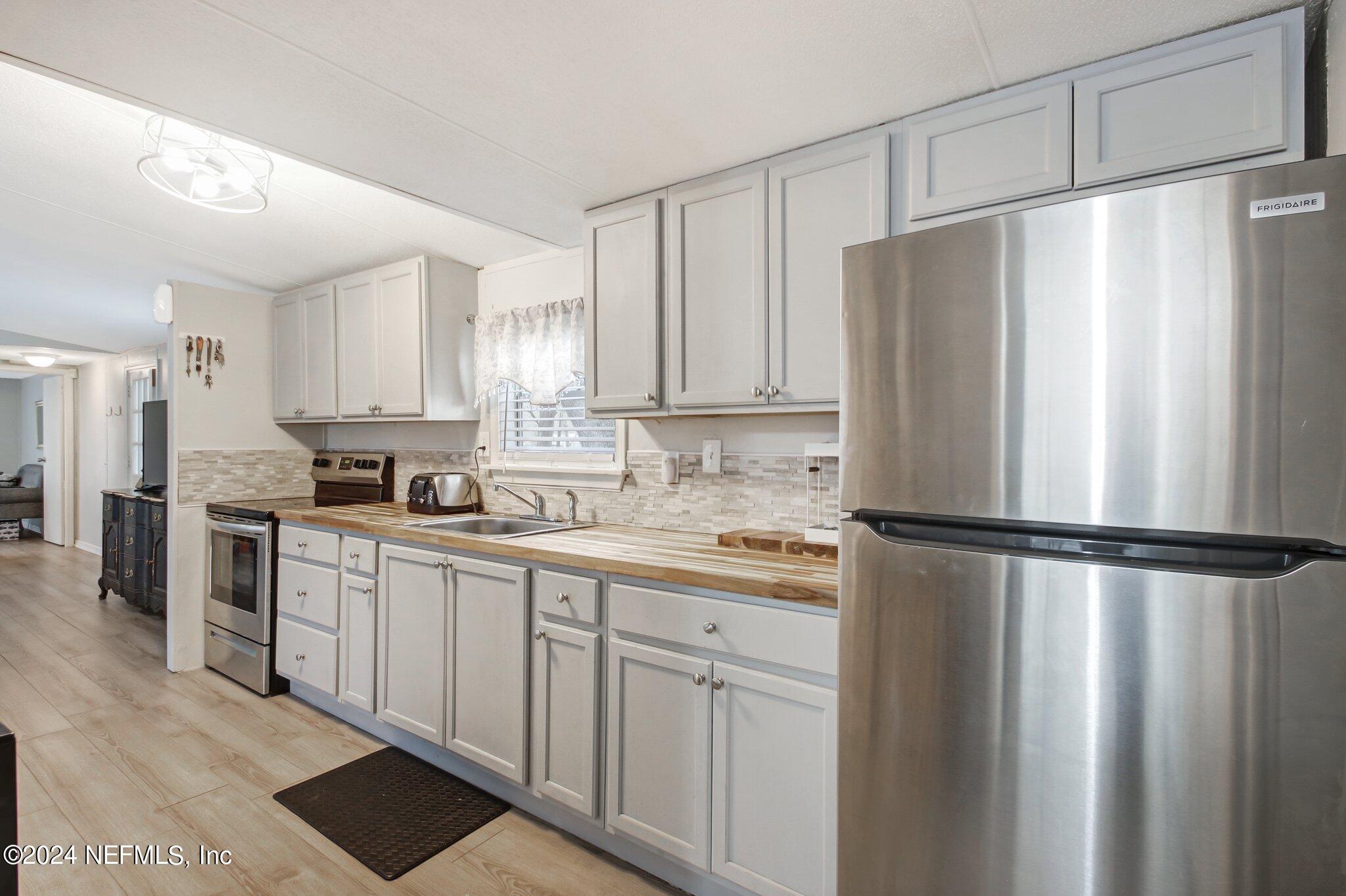 3996 Pinto Road Middleburg, FL 32068 - Photo 15 of 26 a kitchen with stainless steel appliances a refrigerator sink and cabinets