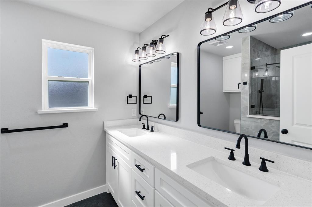 576 Highview Court Godley, TX 76044 - Photo 26 of 40 a bathroom with double vanity sinks and a mirror