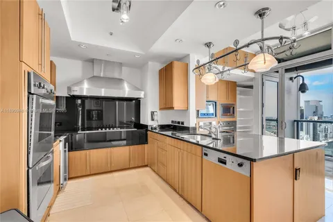 a kitchen with stainless steel appliances granite countertop a sink a oven and a refrigerator