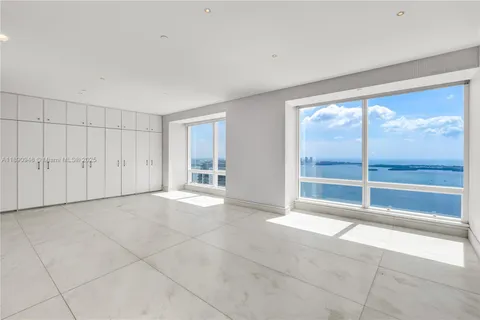 a view of an empty room with a fireplace and a large window