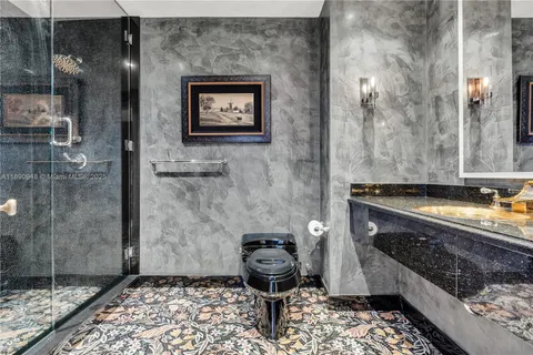 a bathroom with a granite countertop sink a toilet and shower