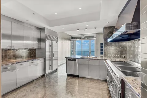 a kitchen with stainless steel appliances a sink a stove and a refrigerator