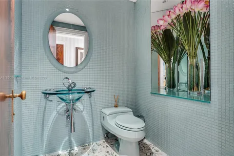 a bathroom with a toilet sink and mirror