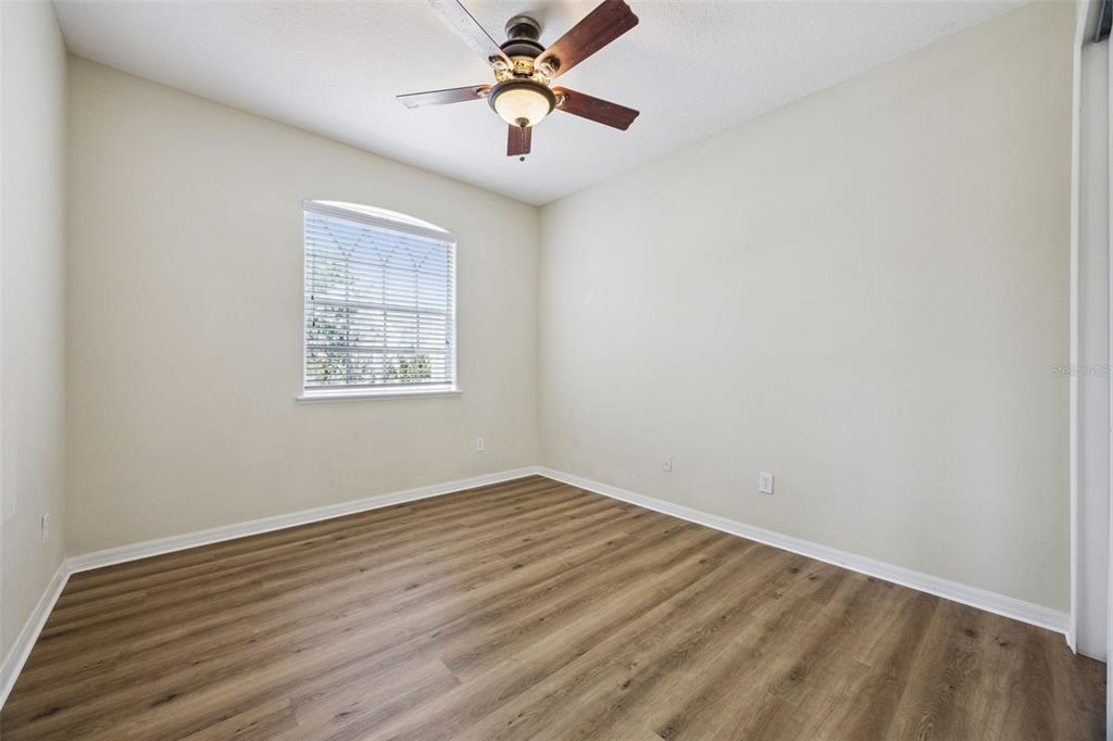 551 Terrace Spring Drive Orlando, FL 32828 - Photo 27 of 41 an empty room with wooden floor chandelier fan and windows