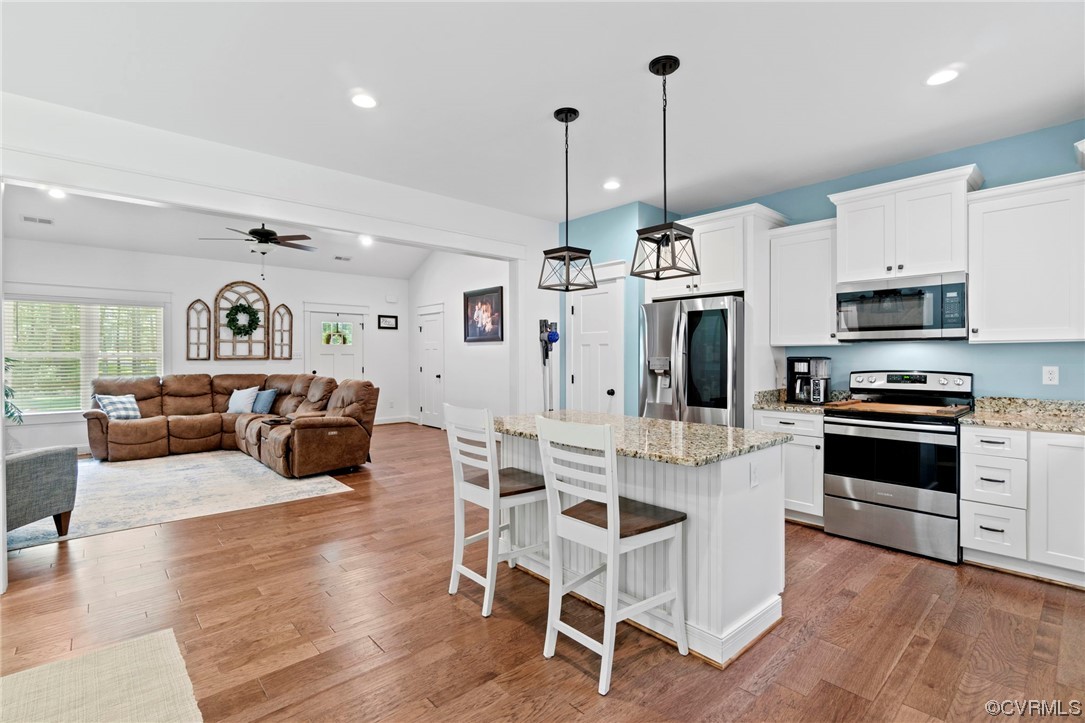 1110 Dorset Road Moseley, VA 23120 - Photo 23 of 32 a kitchen with stainless steel appliances kitchen island granite countertop a stove a refrigerator a kitchen island a dining table and chairs with wooden floor