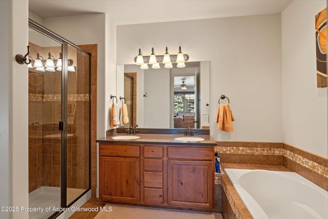a bathroom with a tub sink and mirror