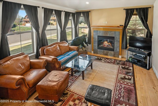 a living room with furniture a floor to ceiling window and a flat screen tv