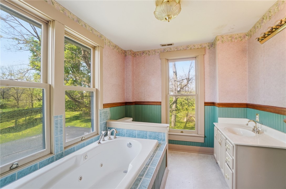 1444 Eagle City Road Springfield, OH 45504 - Photo 36 of 50 Relax in this inviting bathroom featuring a soaking tub and vanity with ample natural light.