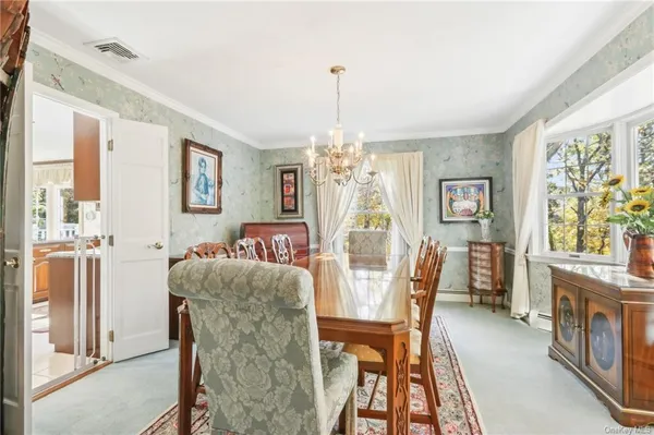 a dining room with furniture a chandelier and wooden floor