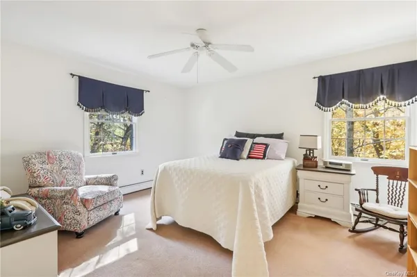 a bedroom with a bed and a dresser next to a window