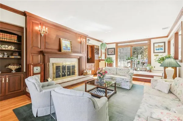 a living room with fireplace furniture and a large window