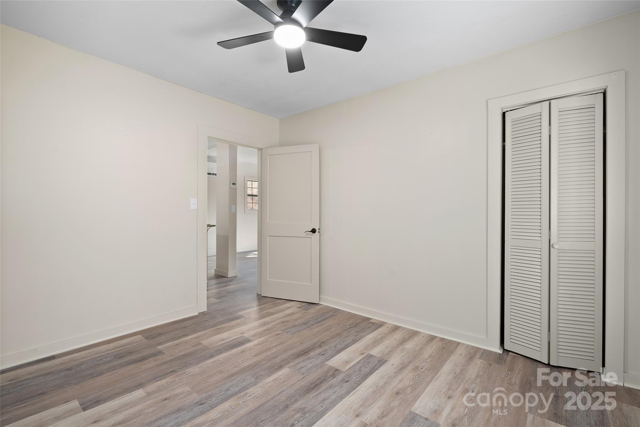 1901 Murray Road Canton, NC 28716 - Photo 17 of 21 an empty room with wooden floor and a ceiling fan
