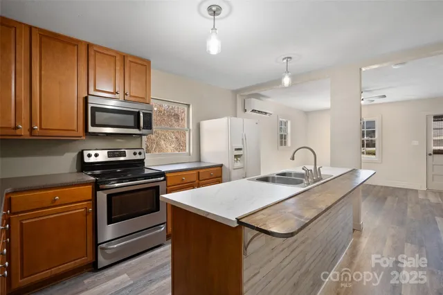 a kitchen with stainless steel appliances granite countertop a stove a sink and a microwave