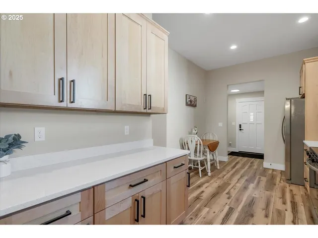 a view of a kitchen with furniture and wooden floor