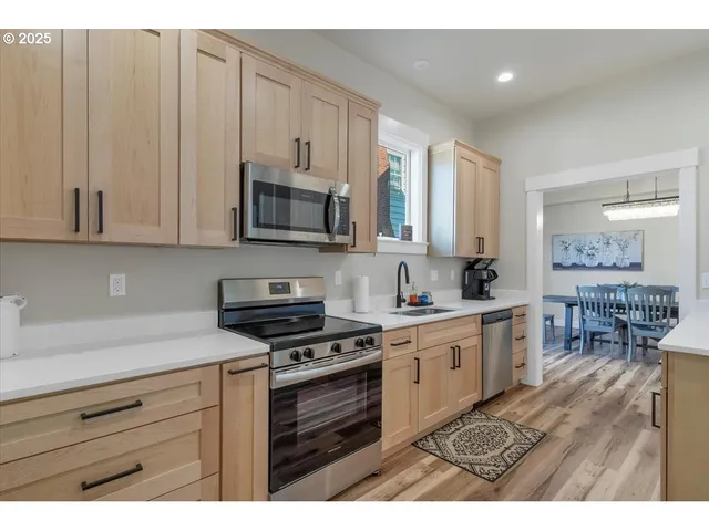 a kitchen with stainless steel appliances granite countertop a stove a sink and a microwave