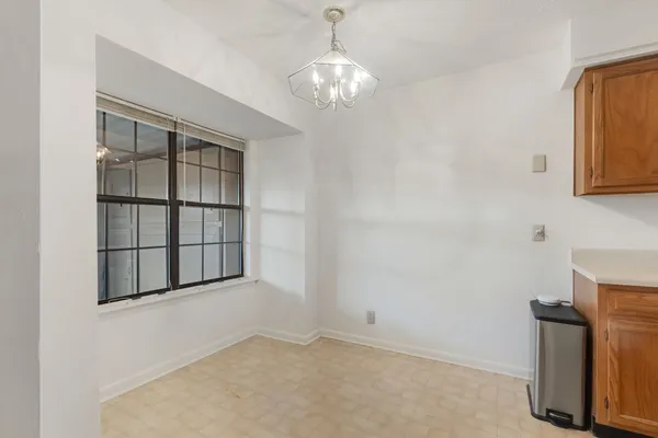an empty room with cabinet and windows