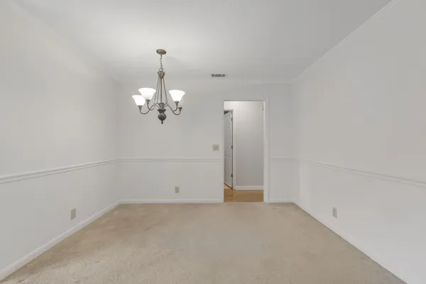 an empty room with chandelier fan