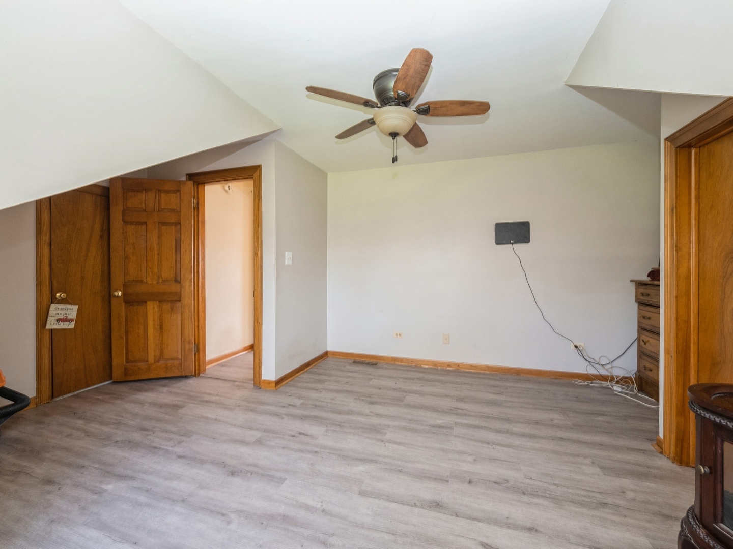 1149 North Doe Road Palatine, IL 60067 - Photo 18 of 46 a view of an empty room with wooden floor and a ceiling fan