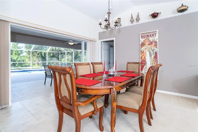 a dining room with furniture a large window and a chandelier