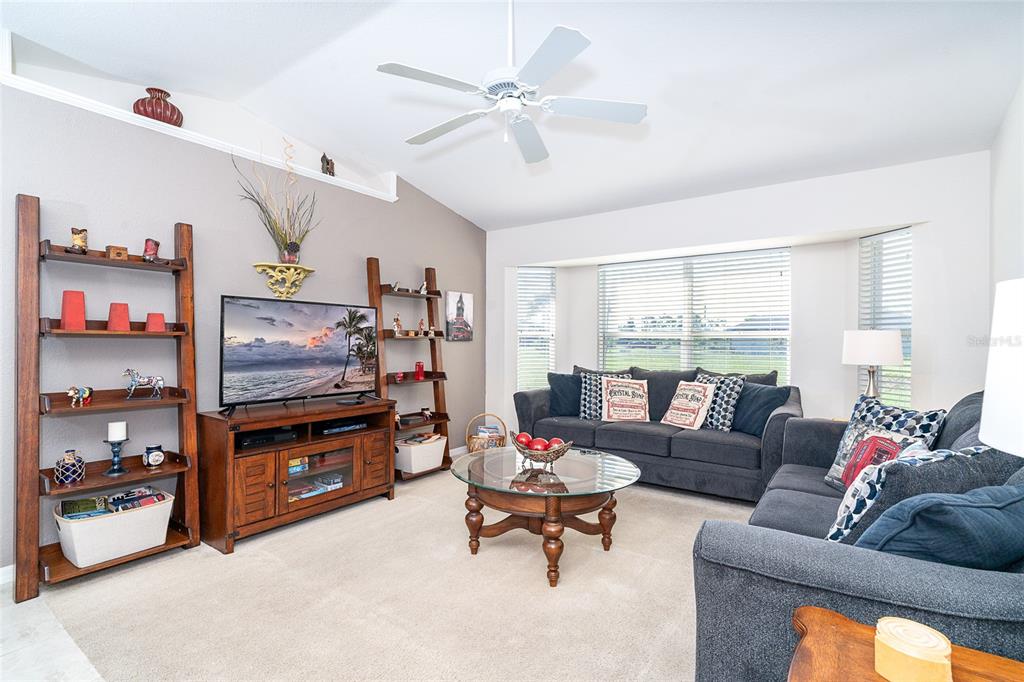 70 Tournament Road Rotonda West, FL 33947 - Photo 13 of 47 a living room with furniture a flat screen tv and a window