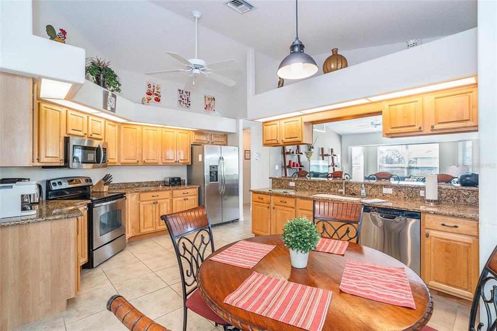 70 Tournament Road Rotonda West, FL 33947 - Photo 18 of 47 a kitchen with stainless steel appliances wooden floor dining table and chairs