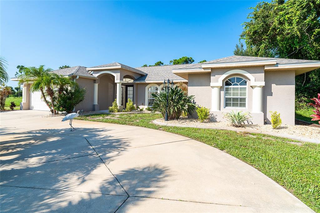 70 Tournament Road Rotonda West, FL 33947 - Photo 2 of 47 a front view of a house with a garden