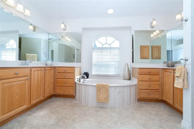 a spacious bathroom with a granite countertop sink mirror and a bathtub