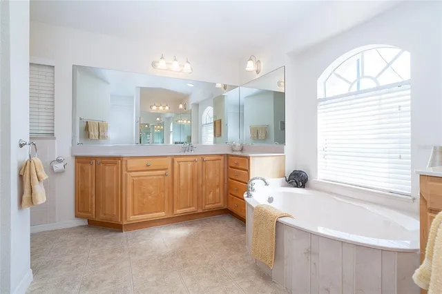 a bathroom with a bathtub a sink and a large mirror