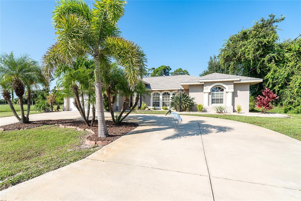 70 Tournament Road Rotonda West, FL 33947 - Photo 5 of 47 a front view of a house with a garden