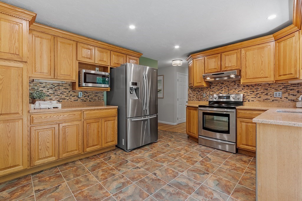 5 Thicket Circle Stow, MA 01775 - Photo 14 of 37 a kitchen with white cabinets and stainless steel appliances