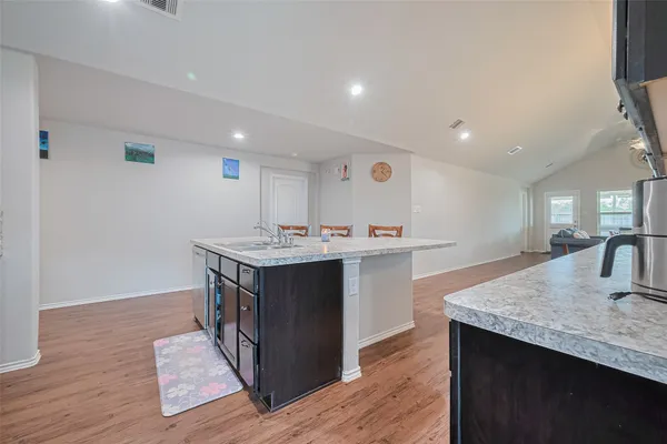 a kitchen with a sink cabinets and wooden floor