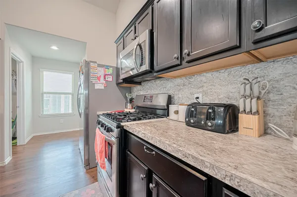a kitchen with stainless steel appliances granite countertop a stove a sink and a microwave