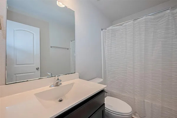 a bathroom with a sink a toilet and a mirror