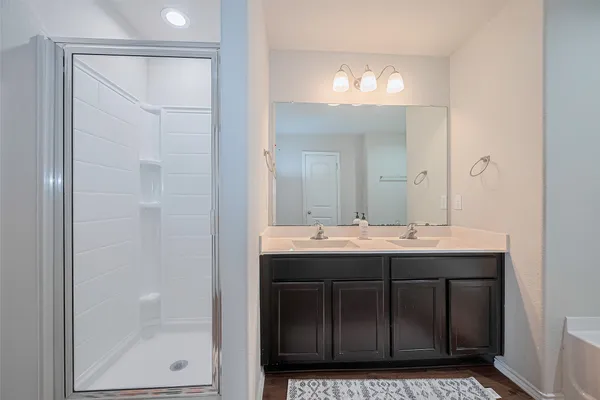 a bathroom with a tub a sink and mirror