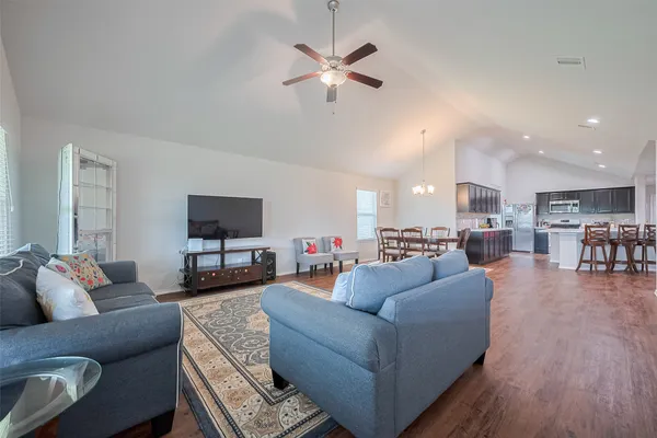 a living room with furniture and a view of kitchen