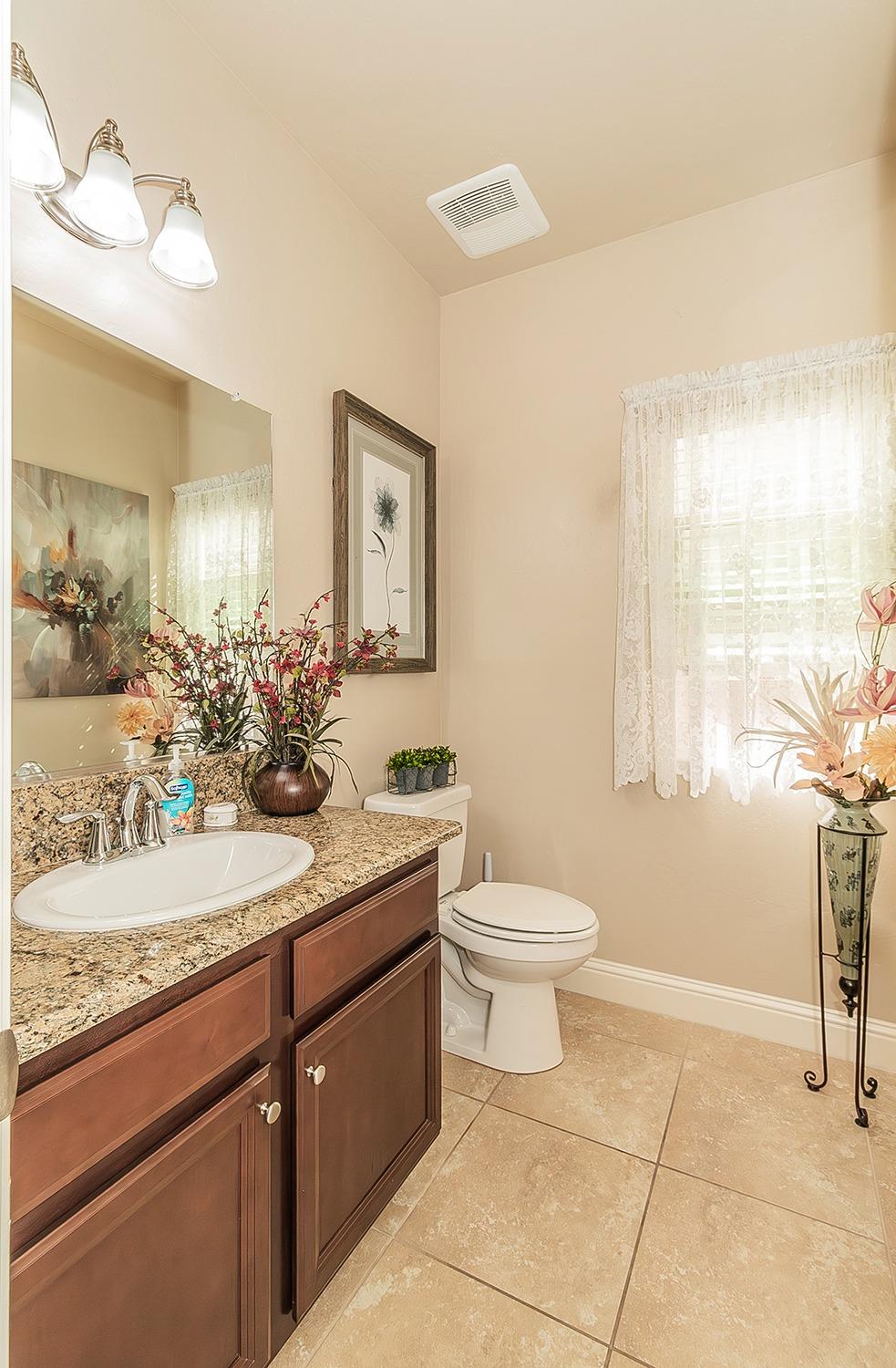 2043 North Soledad Avenue Clovis, CA 93619 - Photo 12 of 33 a bathroom with a granite countertop sink a toilet and mirror