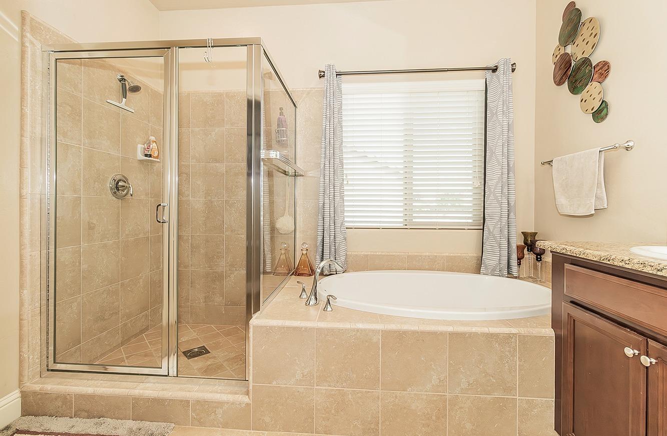 2043 North Soledad Avenue Clovis, CA 93619 - Photo 18 of 33 a bathroom with a granite countertop tub shower and sink