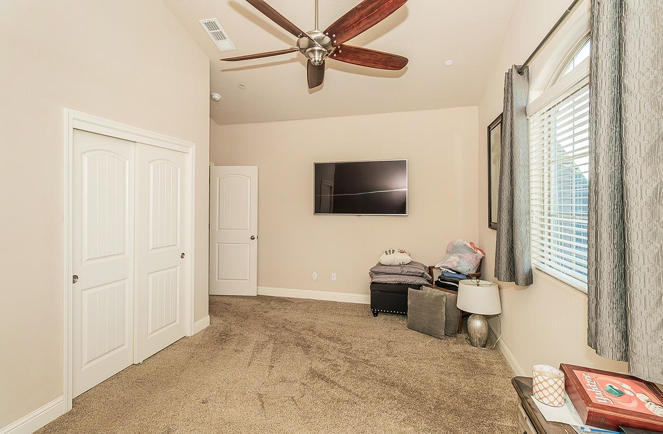 2043 North Soledad Avenue Clovis, CA 93619 - Photo 27 of 33 a living room with a flat screen tv a rug and a ceiling fan
