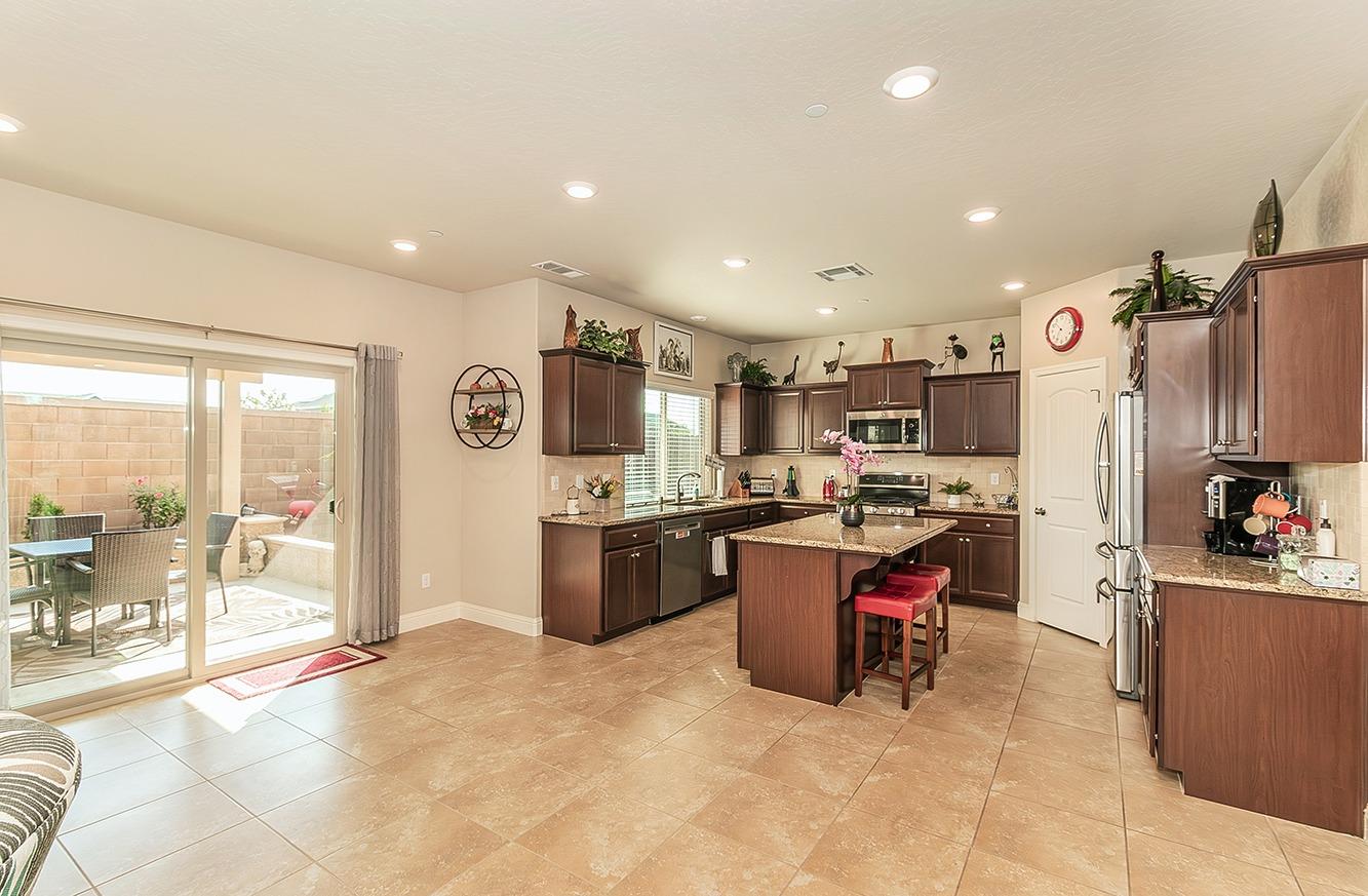 2043 North Soledad Avenue Clovis, CA 93619 - Photo 5 of 33 a kitchen with stainless steel appliances kitchen island granite countertop a sink refrigerator and cabinets