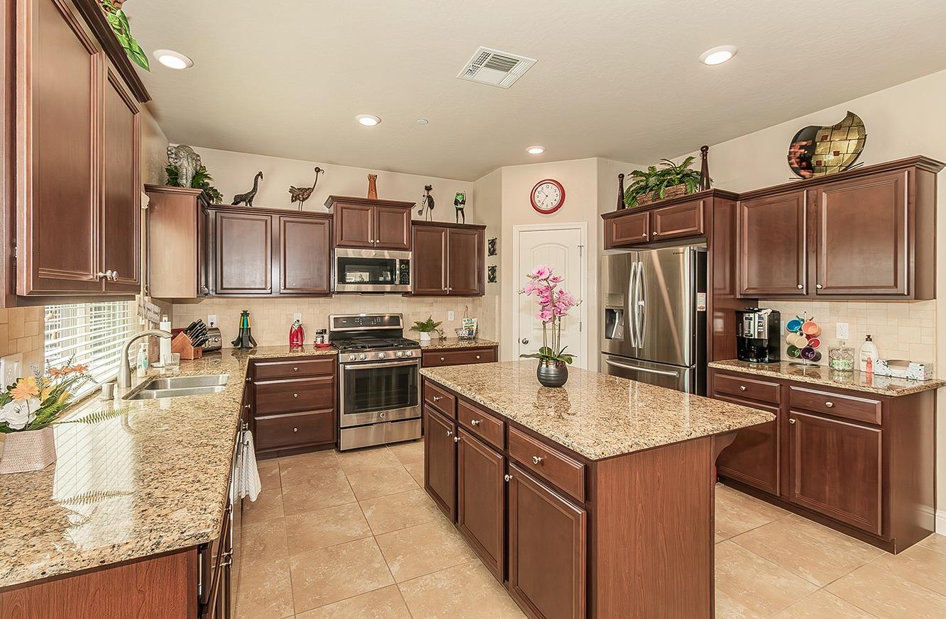 2043 North Soledad Avenue Clovis, CA 93619 - Photo 7 of 33 a kitchen with kitchen island granite countertop a sink counter top space appliances and cabinets