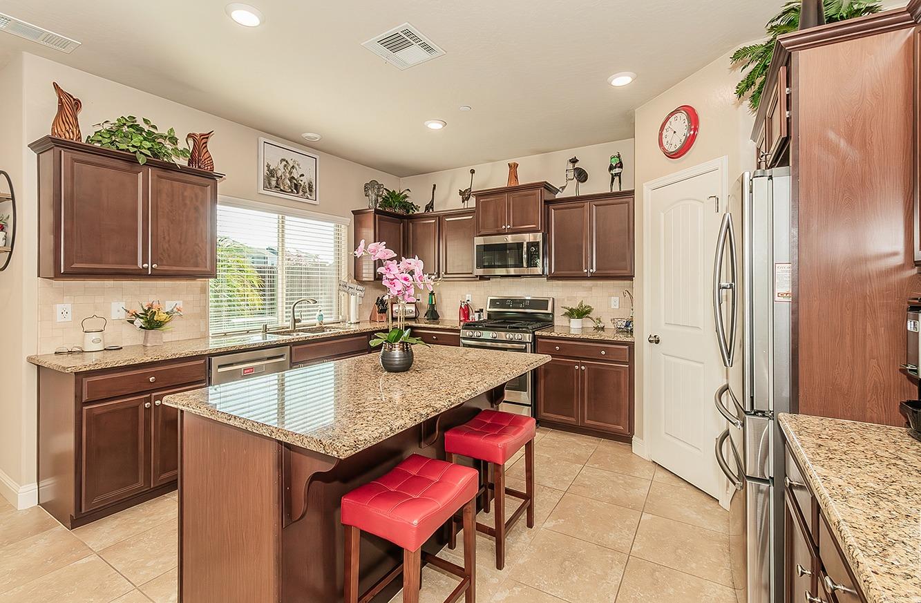 2043 North Soledad Avenue Clovis, CA 93619 - Photo 9 of 33 a kitchen with stainless steel appliances granite countertop a sink stove and refrigerator