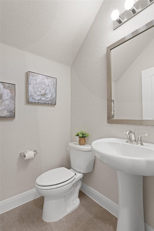 10502 Turnbull Loop, Unit 41 Austin, TX 78717 - Photo 12 of 29 Half bath featuring light tile patterned flooring, lofted ceiling, a textured wall, and a textured ceiling