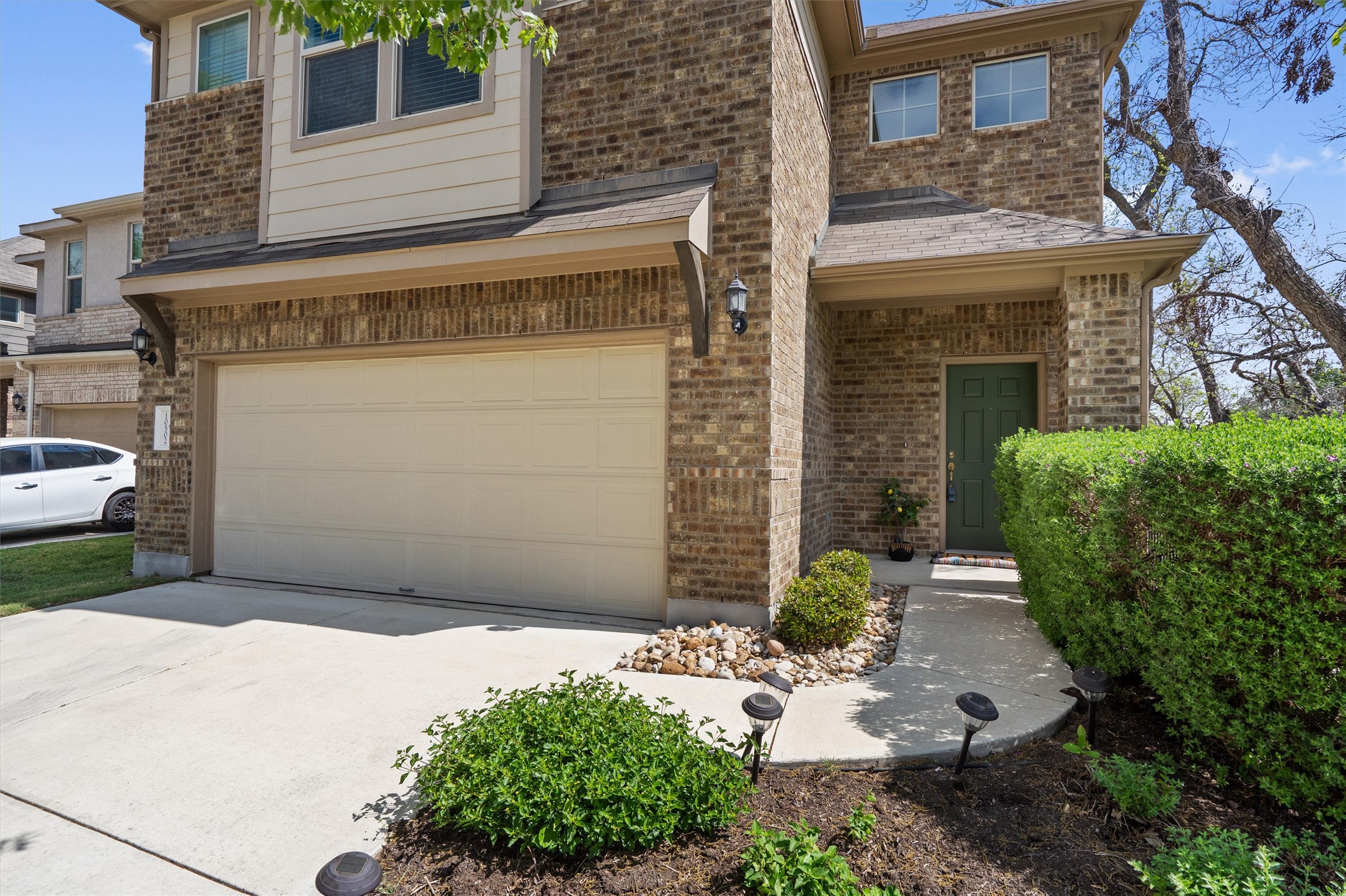 10502 Turnbull Loop, Unit 41 Austin, TX 78717 - Photo 2 of 35 View of front of house with brick siding, driveway, and an attached garage
