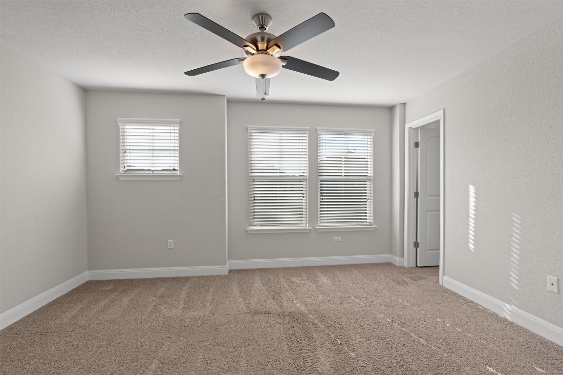 10502 Turnbull Loop, Unit 41 Austin, TX 78717 - Photo 21 of 29 Unfurnished room featuring light carpet, plenty of natural light, and ceiling fan