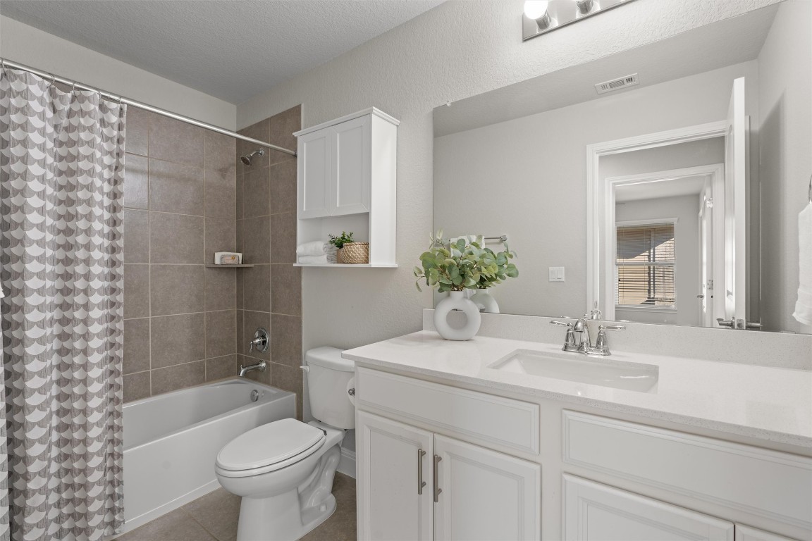10502 Turnbull Loop, Unit 41 Austin, TX 78717 - Photo 23 of 29 Full bathroom with shower / bath combo with shower curtain, vanity, light tile patterned floors, and a textured ceiling